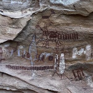 Painel de pinturas rupestres na Serra da Capivara, com figuras humanas e animais em vermelho e branco